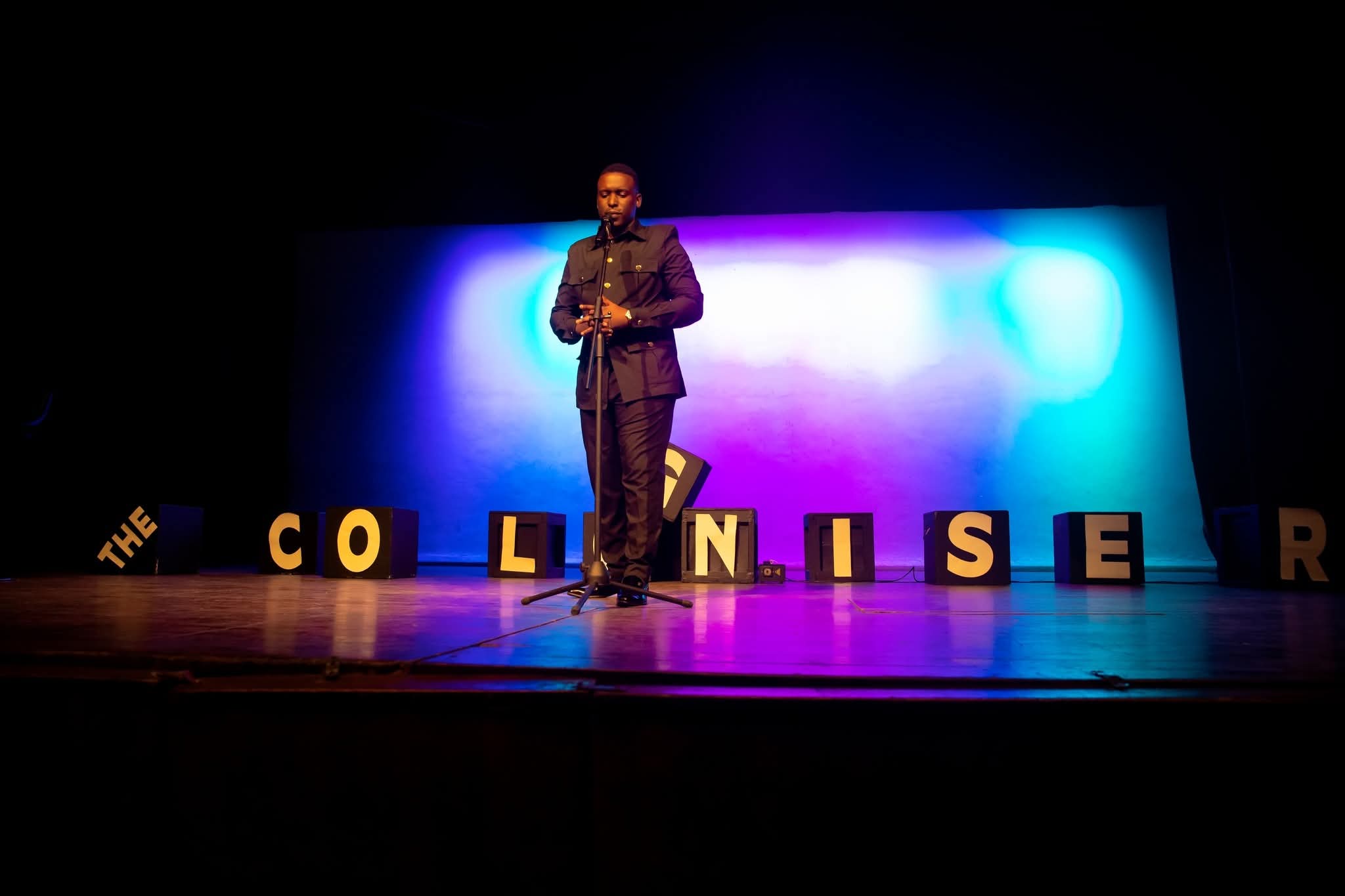 Andrew Manyika performing live under stage lighting